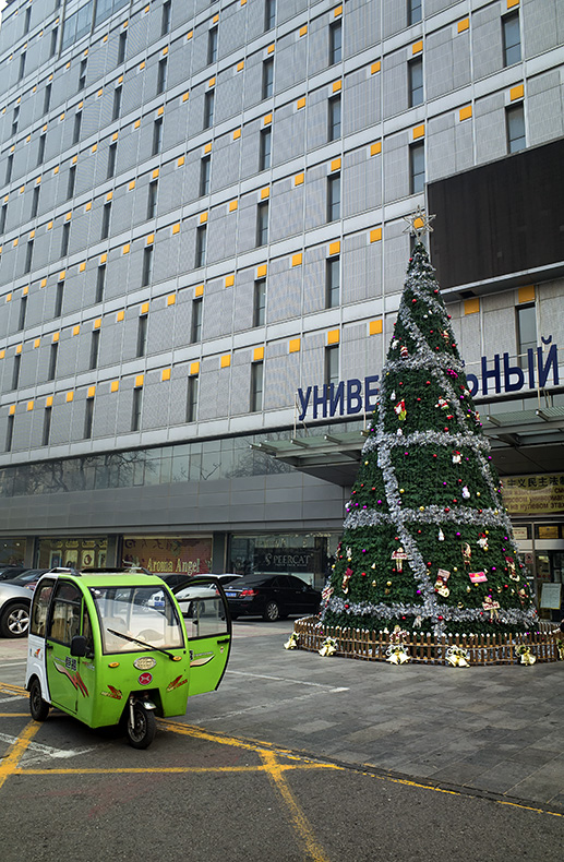 Three-wheel taxi and Christmas tree outside a Russian shopping mall on Yabao Road, Russia Town, Beijing, China.