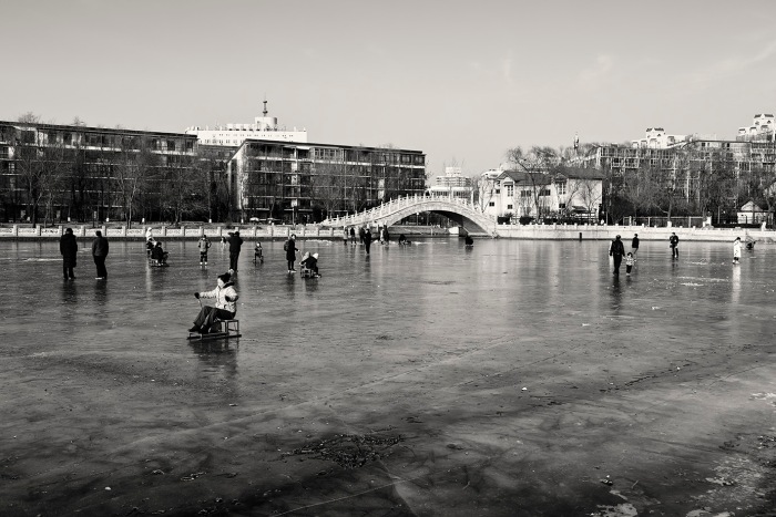 People on the frozen marina at the Nanchang River, Xicheng, Beijing, China.