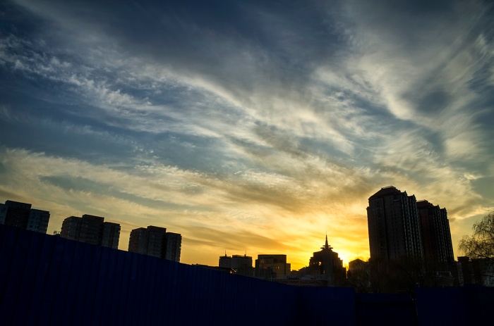 Setting sun silhouettes the skyline of Chaowai, Beijing, China.