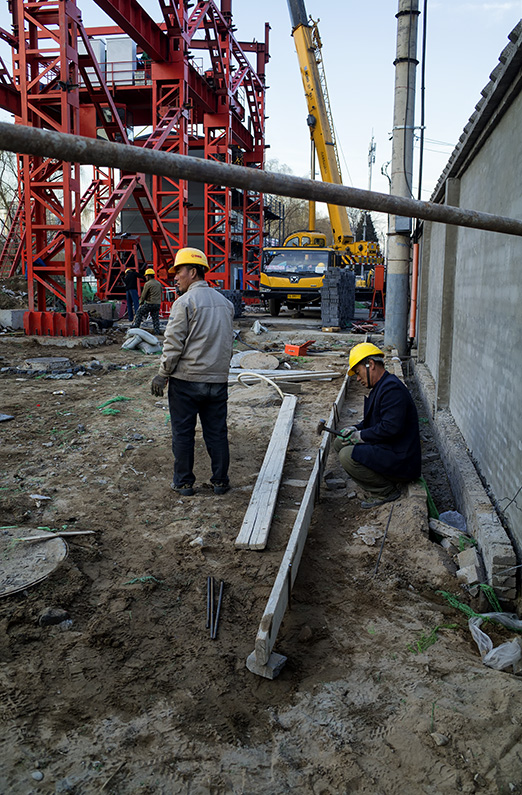 Construction workers on the site of a new subway station on Workers Stadium E Road, Sanlitun, Beijing, China.
