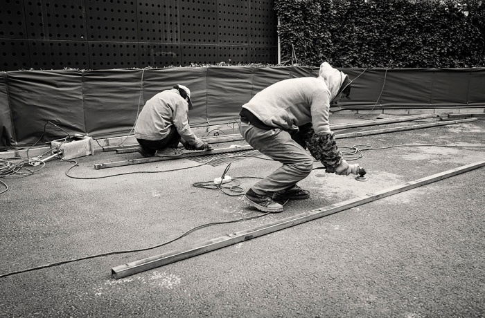 Workman with an angle grinder working on a metal strut at Zhongguancun Creative Park, Haidian, Beijing, China.